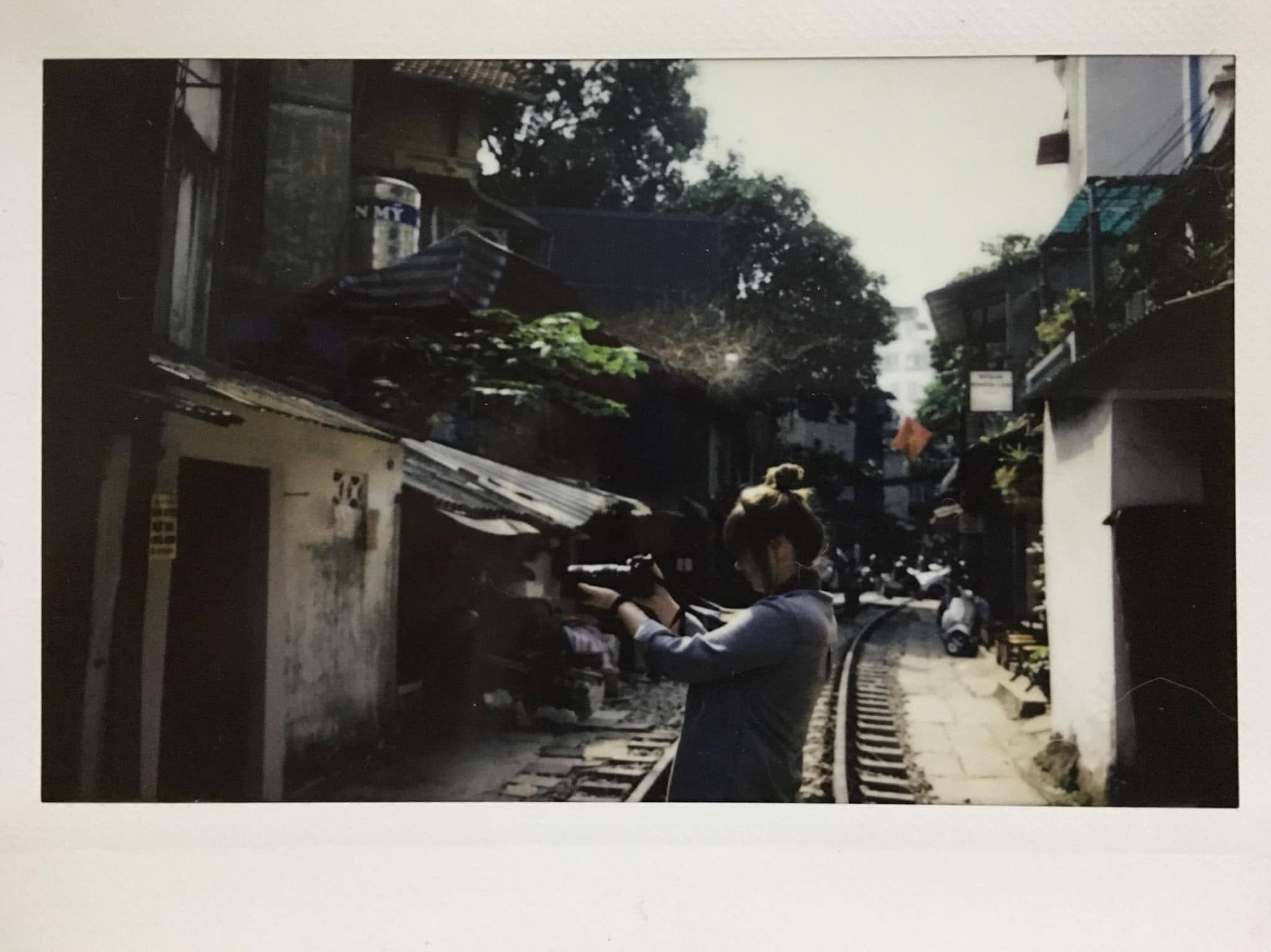 Kate taking photos on a street beside train tracks